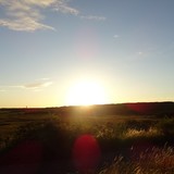 De zon die achter de duinen verdwijnt bezien vanuit De Zwarte Polder op dinsdag 21 juli 2015.