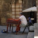 Deze man zat er in april 2014 ook al met zijn piano-achtig muziekinstrument.